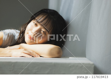 西陽の窓辺の女性 117819413