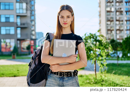 Portrait young female college student holding laptop computer outdoor Portrait young female college student holding laptop computer outdoor 117820424