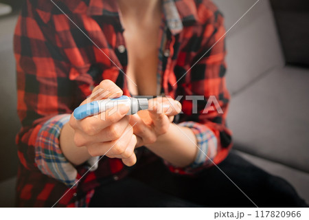 Woman measuring glucose level blood test 117820966