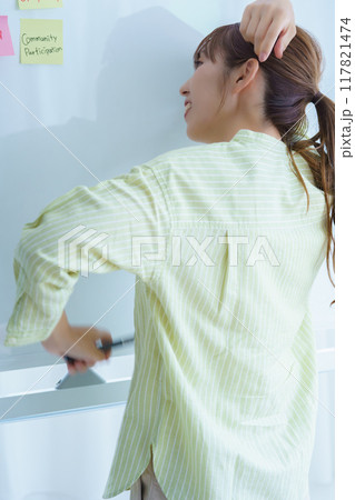 オフィスで課題を見える化する若い女性 117821474