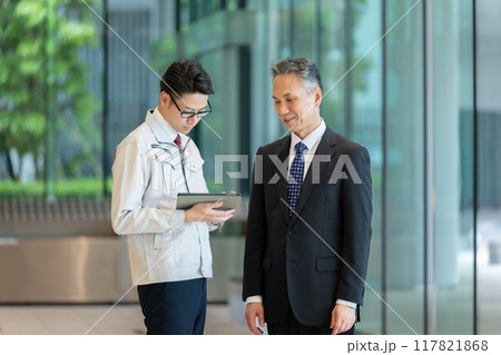 ロビーで商談する作業服の男性 117821868