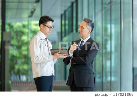 ロビーで商談する作業服の男性 117821869