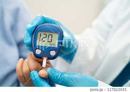 Doctor use digital glucose monitor measure and test stripe for check diabetes from finger blood sugar level. 117822031