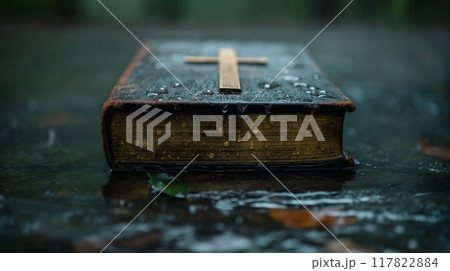 Antique bible with a wooden cross in the rain 117822884