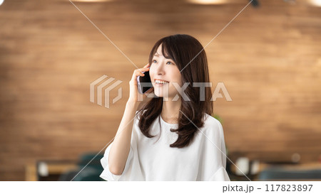 スマホで話す笑顔のビジネスウーマン スマホで話す笑顔のビジネスウーマン 117823897