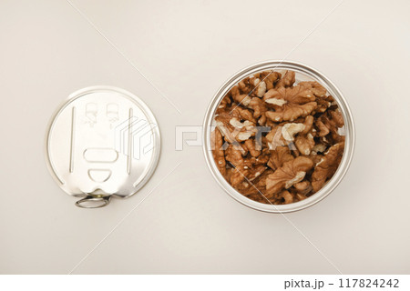 Walnuts in a plastic jar on a white background. 117824242