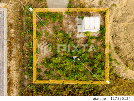 An abandoned or unattended site of a linear remote controlled crane on a gas pipeline overgrown with grass 117826124