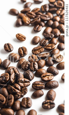 Rich and dark roasted coffee beans lay scattered across a vibrant white surface Rich and dark roasted coffee beans lay scattered across a vibrant white surface 117826481