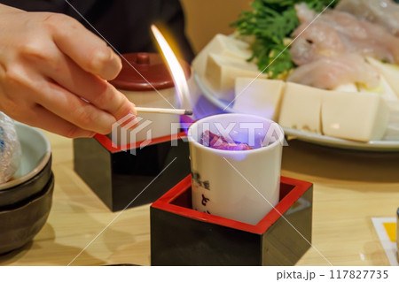 トラフグのひれ酒。熱燗に炙ったフグのヒレを入れる。飲む直前にフランベしてアルコールを飛ばす。  117827735