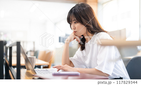 パソコンを使いながら考える女性 パソコンを使いながら考える女性 117829344