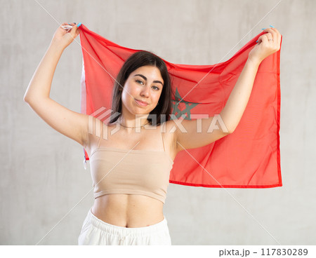 Young woman with flag of Morocco posing in studio 117830289