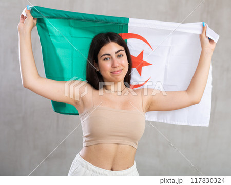 Young woman with flag of Algeria posing in studio 117830324