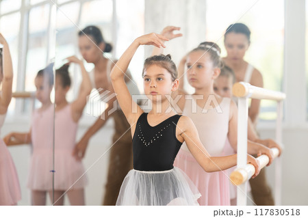 Woman teacher corrects girls in batman tandu movement 117830518