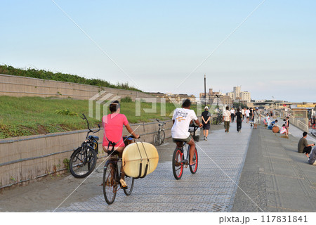 自転車で片瀬西浜遊歩道を移動するサーファー 117831841