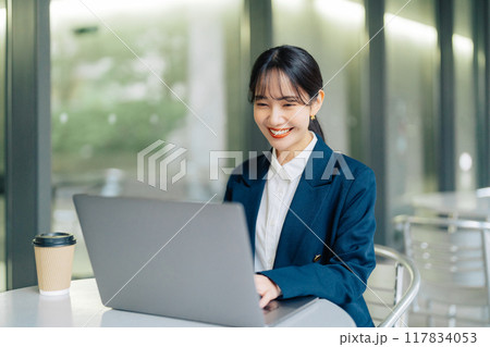 カフェのテラスでパソコンを使う女性 117834053
