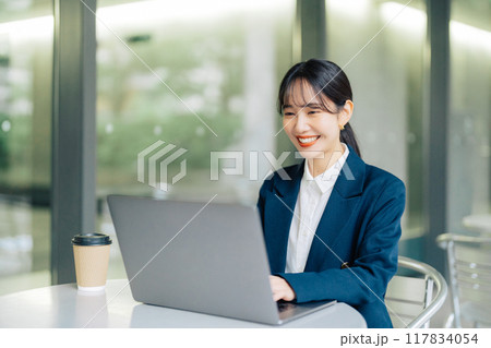 カフェのテラスでパソコンを使う女性 カフェのテラスでパソコンを使う女性 117834054
