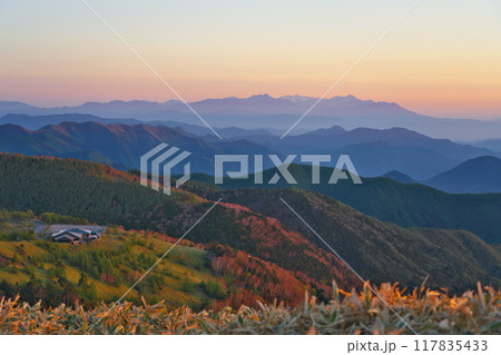 朝日に映える美ヶ原高原と、遠く戸隠連峰の空に広がるビーナスベルト 117835433