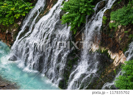 青い川に流れ落ちる緑に包まれた白ひげの滝 117835702