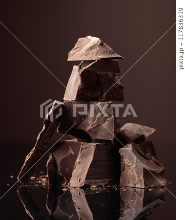 Pieces of bitter chocolate on a dark background. Pieces of bitter chocolate on a dark background. 117836319