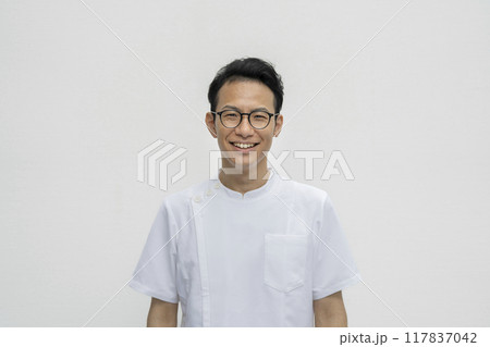 白衣を着たカメラ目線で笑顔の30代の男性　医療従事者イメージ　 117837042