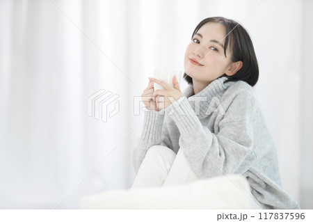 コーヒーを飲むセーターを着た若い女性 コーヒーを飲むセーターを着た若い女性 117837596