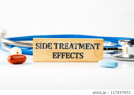 Conceptual side effects symbol. Copy space. SIDE TREATMENT EFFECTS words written on a wooden block with a stethoscope lying next to it, pills, vitamins on a white background 117837652