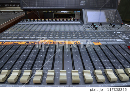 Buttons, levels, switches, speaker volume control on an audio mixer control panel set at the TV studio 117838256