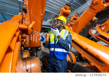African American man engineer standing holding walkie talkie at automation robot arms 117838272