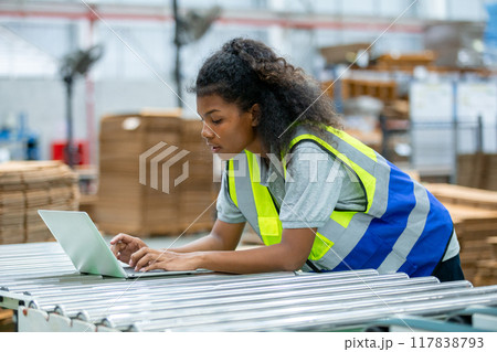 Supervisor worker woman american african using laptop check quality and quantity stock paper product Supervisor worker woman american african using laptop check quality and quantity stock paper product 117838793