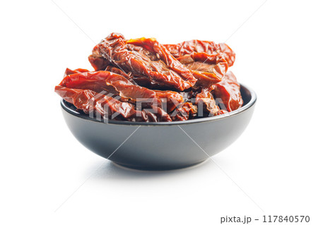 Sun dried red tomatoes in bowl isolated on white background. Sun dried red tomatoes in bowl isolated on white background. 117840570