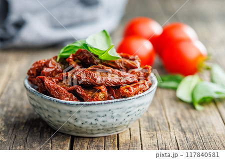 Sun dried red tomatoes in bowl on wooden table. Sun dried red tomatoes in bowl on wooden table. 117840581