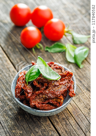 Sun dried red tomatoes in bowl on wooden table. Sun dried red tomatoes in bowl on wooden table. 117840582