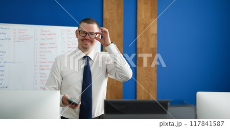 Happy male business coach in the office, close-up Happy male business coach in the office, close-up 117841587