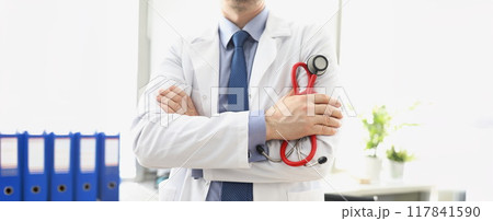 Male doctor in a white coat with a stethoscope in his hands Male doctor in a white coat with a stethoscope in his hands 117841590