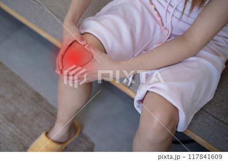 Woman Massaging Sore Knee at Home. Knee Pain Management 117841609