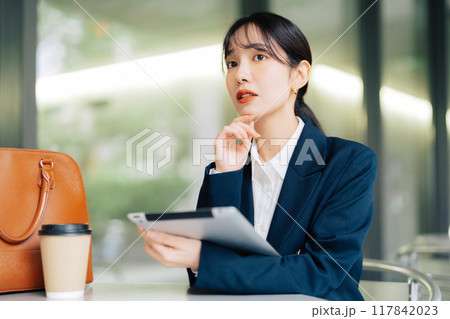 カフェのテラスでタブレットを使う女性 カフェのテラスでタブレットを使う女性 117842023