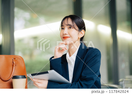 カフェのテラスでタブレットを使う女性 カフェのテラスでタブレットを使う女性 117842024