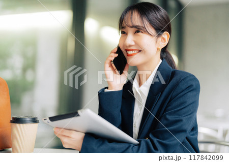 カフェのテラスで電話をする女性 117842099