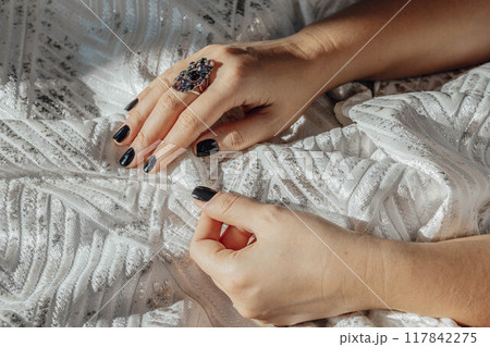 hand holding lavishly designed white fabric, capturing fine details and luxurious quality that define high-end fashion 117842275