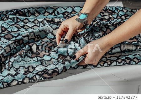 hand interacting with richly textured fabric, symbolizing craftsmanship and creativity behind every piece of fashion 117842277