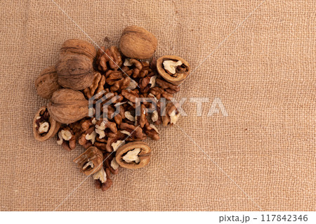 heap of walnuts on burlap with copy space heap of walnuts on burlap with copy space 117842346