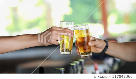 Male hands with glasses of beer clink glasses 117842366