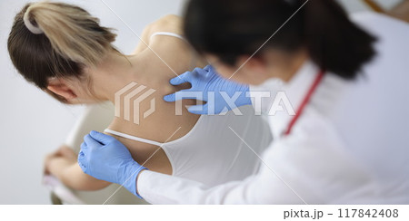 Chiropractor doctor presses on a woman's spine 117842408