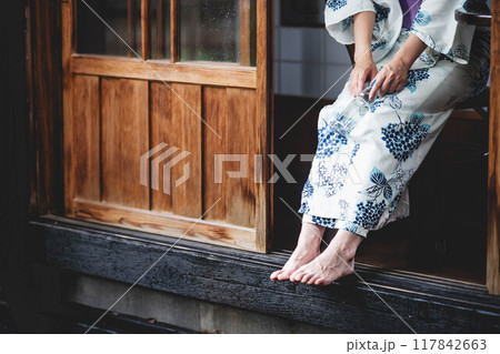 縁側に座る浴衣姿の若い女性 117842663