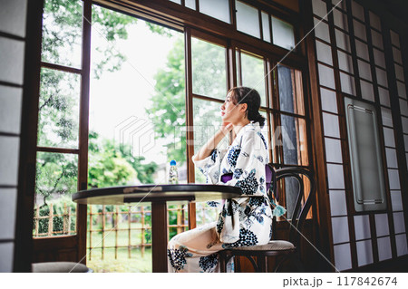 縁側に座る浴衣姿の若い女性 117842674