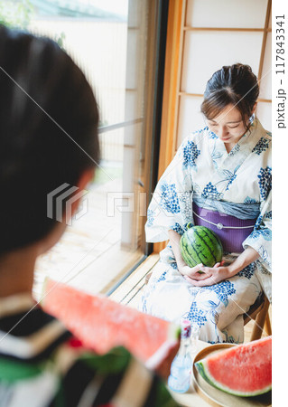 スイカを食べる浴衣の女性 117843341