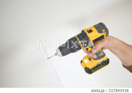 using electric drilling on white wooden board using electric drilling on white wooden board 117843536