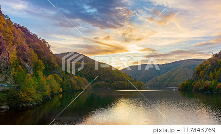 lake in mountains on a sunny evening. forest reflecting in the water. beautiful scenery of romania in autumn season. picturesque cloudscape 117843769
