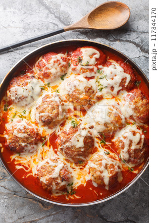 Close-up of meatball casserole in tomato sauce with mozzarella cheese in a baking dish. Vertical top view 117844170