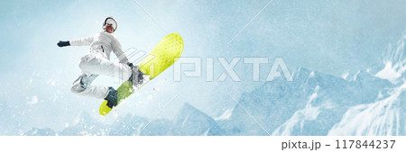 Snowboarder performing high-flying trick in air, against stunning backdrop of snow-covered mountains, capturing thrill and freedom of winter sports. Snowboarder performing high-flying trick in air, against stunning backdrop of snow-covered mountains, capturing thrill and freedom of winter sports. 117844237